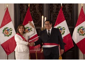 Dina Boluarte, Peru's president, left, shakes hands with Alex Contreras, Peru's new economy minister, during a cabinet swearing in ceremony at the Government Palace in Lima, Peru, on Saturday, Dec. 10, 2022. Boluarte is trying to seek allies and establish her authority after the chaos triggered by Castillo's attempt to dissolve congress.