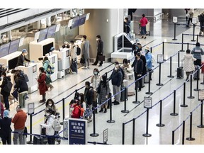 Travelers check in for a flight at the Hongqiao International Airport in Shanghai, China, on Monday, Dec. 12, 2022. Chinese officials continued to downplay the risks of Covid-19 as restrictions are eased, with a top medical adviser saying the fatality rate from the omicron variant of the virus is in line with influenza. Photographer: Qilai Shen/Bloomberg