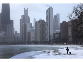 A man walks his dog along the Chicago lake front near downtown as temperatures hover about -6 degrees Fahrenheit on Dec. 22, 2022. The city has faced wind chills dipping as low as -40 degrees.