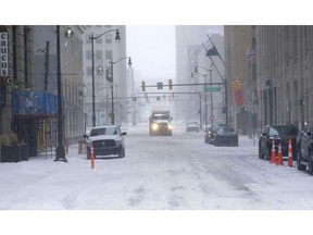 Vehicles try to clear roads in downtown Detroit on Dec. 23.