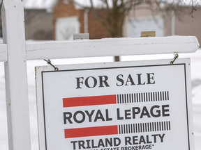 For sale sign in front of house