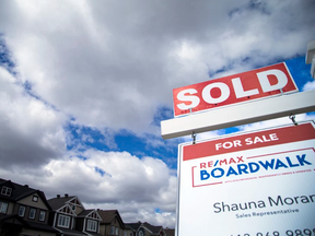 Sale sign in front of houses