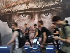 FILE - Visitors passing an advertisement for the video game 'Call of Duty' at the Gamescom fair for computer games in Cologne, Germany, Tuesday, Aug. 22, 2017. Microsoft says it struck a deal to make the hit video game Call of Duty available on Nintendo for 10 years when its $69 billion purchase of game maker Activision Blizzard goes through. The announcement Wednesday, Dec. 7, 2022 is an apparent attempt to fend off objections from rival Sony.