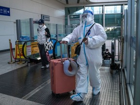 A traveler in protective gear at a train station in Beijing, China, on Dec. 21, 2022. China's broad budget deficit hit a record so far this year, showing how damaging the now abandoned Covid Zero policy and the ongoing housing slump have been to the economy and to the government's finances.