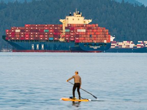 Container ships sit in the waters of English Bay in Vancouver, B.C.