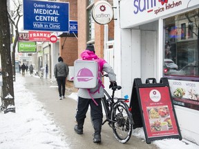 A Foodora courier picks up an order for delivery from a restaurant in Toronto.