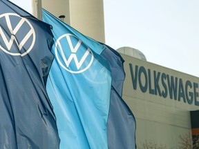 Company logo flags wave in front of a Volkswagen factory building in Zwickau, Germany, April 23, 2020. Volkswagen AG says it has started searching in Canada for the site of its first battery factory in North America.