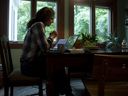 A person participates in a conference call while working from home. 