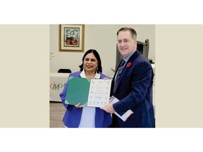 Owner Lakshmi Bhamidipati (left) is presented with a Certificate of Appreciation by Chief Guest Brian Masse, Member of Parliament (right) at the Grand Opening for Minuteman Press, Windsor, Ontario, November 9th, 2022.