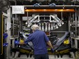 An employee assembles a bumper at an auto parts manufacturing facility in Guelph, Ont.