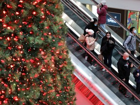 Shoppers pass by the Christmas tree at Eaton Centre mall in downtown Toronto.