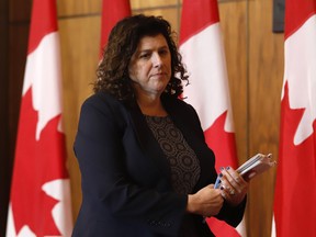 Auditor general Karen Hogan leaves after speaking at a news conference in Ottawa.
