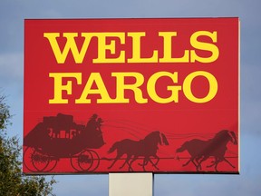 FILE - A Wells Fargo sign stands in front of a branch of the bank in Bradenton, Fla., Tuesday, Feb. 22, 2022. Consumer banking giant Wells Fargo is being ordered to pay $3.7 billion in fines and refunds to customers by U.S. government regulators, the largest fine to date against the bank.