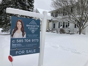 FILE - A "For Sale" sign stands in front of a house in Rochester, New York, on Monday, January 17, 2022. On Wednesday the National Association of Realtors reports on sales of existing homes in November.