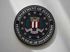 FILE - An FBI seal is seen on a wall on Aug. 10, 2022, in Omaha, Neb. A hacker who reportedly posed as the CEO of a financial institution claims to have obtained access to the more than 80,000-member database of InfraGard, an FBI-run outreach program that shares sensitive information on national security and cybersecurity threats with public officials and private sector individuals who run U.S. critical infrastructure.