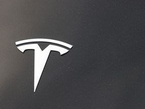 FILE - The Tesla company logo is seen on the hood of an unsold vehicle at a dealership, Aug. 9, 2020, in Littleton, Colo. The U.S. government's highway safety agency said Thursday, Dec. 22, 2022, that it will send a team to investigate a Thanksgiving Day pileup on the San Francisco-Oakland Bay Bridge involving a Tesla that may have been using the company's "Full Self-Driving" software.
