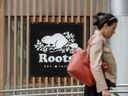 A pedestrian walks past a Roots store in Toronto.