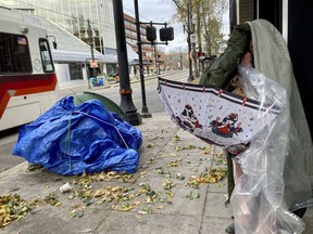 A homeless man who spent the night outside in temperatures that dipped into the single digits attempts to find shelter from the frigid cold on Thursday, Dec. 22, 2022, in Portland, Ore.