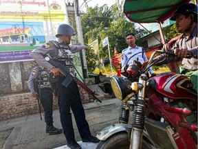 Armed policemen inspect a tricycle at a roadside checkpoint during the visit of the Myanmar junta leader Min Aung Hlaing to Thanlyin township, on the outskirts of Yangon on December 24, 2022.  Photographer: NurPhoto/Getty Images