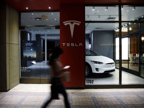 A pedestrian walks past a Tesla Inc. store in Palm Desert, California.