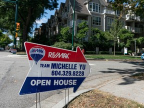 An open house sign on the corner of a street in Vancouver.