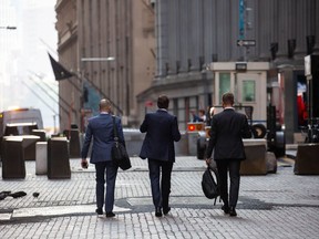 Pedestrians walk along Wall Street near the New York Stock Exchange.