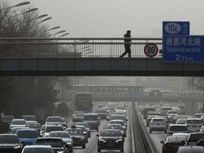 Vehicles move on a city highway in Beijing, Monday, Dec. 12, 2022, as capital city is hit by sandstorm. China will drop a travel tracing requirement as part of an uncertain exit from its strict 