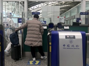 CORRECTS DAY AND DATE IN SECOND SENTENCE - An inbound traveler prepare to cross immigrations at the Guangzhou Baiyun Airport in southern China's Guangdong province on Dec. 25 2022. The Chinese government said Tuesday, Dec. 27 it will start issuing new passports as it dismantles anti-virus travel barriers, setting up a potential flood of millions of tourists out of China for next month's Lunar New Year holiday.