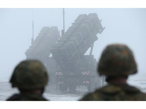 WARBELOW, GERMANY - DECEMBER 18: Members of the German Bundeswehr look on as two Patriot missile launching systems stand ready during a press day presentation at the Luftwaffe Warbelow training center on December 18, 2012 in Warbelow, Germany. Germany, along with the USA and the Netherlands, will send two Patriot systems to Turkey in January to protect Turkey from Syrian attacks.