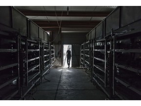 A technician exits a warehouse containing bitcoin mining machines at a mining facility operated by Bitmain Technologies Ltd. in Ordos, Inner Mongolia, China, on Friday, Aug. 11, 2017. Bitmain is one of the leading producers of bitcoin-mining equipment and also runs Antpool, a processing pool that combines individual miners from China and other countries, in addition to operating one of the largest digital currency mines in the world.