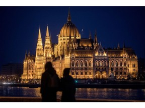 BUDAPEST, HUNGARY - JANUARY 19: People look out over The Hungarian Parliament Building on January 19, 2019 in Budapest, Hungary. The Parliament building has become a site of growing protests over the past months. Over the past months thousands of Hungarians have turned out in the streets to call for the resignation of Prime Minister Viktor Orban. Orban was reelected for a third term in April 2018, since taking office Orban, has rebranded his ruling party Fidesz, once a liberal youth party, as a right-wing Christian nationalist organization. After the party's victory in 2010, Orban moved to remake Hungary as what he termed "an illiberal state." Since then, Orban has introduced many changes and new laws to realize this vision: the court system has been stacked with government loyalists; Orban's allies have taken control of most Hungarian media; a new labor law - dubbed the "slave law" by critics - has increased the limit on overtime from 250hrs to 400hrs per year; the "Stop Soros" bill targeted NGOs and individuals assisting refugees and migrants; accreditation laws for foreign universities were changed, forcing the renowned Central European University to move most operations to Vienna; and a new homeless law that criminalizes sleeping on the streets. Mr. Orban's moves have created a template for his brand of illiberal democracy, which is providing inspiration to far-right and populist leaders in Poland, Italy, France, Netherlands and Brazil.