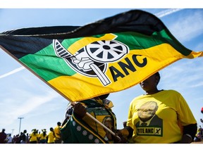 Supporters wearing party colors wave a flag during an African National Congress party (ANC) campaign event in Bloemfontein, South Africa, on Sunday, April 7, 2019. The ANC is expected to easily maintain its monopoly on power in the May 8 national elections, albeit with a slightly reduced majority.