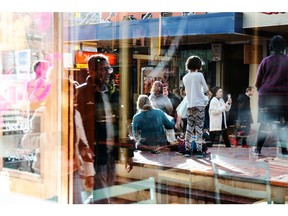 Pedestrians are reflected in a store window in Wellington, New Zealand, on Saturday, June 22, 2019. The out-of-favor kiwi dollar has tumbled about 3% this quarter as the Reserve Bank of New Zealand turned dovish and cut interest rates, the first central bank in the developed world to do so. Economic growth held at a five-year low in the three-months through March, leaving the door open for further easing.