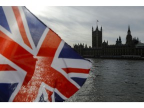 A British Union flag, also known as a Union Jack, flies from a tourist souvenir stall on the bank of the River Thames in view of the Houses of Parliament in London, U.K., on Wednesday, Oct. 30, 2019. U.K. Prime Minister Boris Johnson has succeeded, finally, in getting Parliament to give him the general election that he wants.