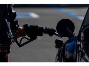 A person holds a fuel pump nozzle at a Chevron Corp. gas station in San Francisco, California, U.S., on Thursday, March 11, 2021. Northern Californians are taking to the open road in much greater numbers, an early signal that gasoline demand may be returning a year after the pandemic paralyzed the economy.