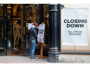 A worker places a closing down sale sign at the entrance to Jack Wills Retail Limited clothing store in Birmingham, U.K., on Monday, April 12, 2021. Non-essential retailers as well as pubs and restaurants with outdoor space will reopen Monday across England after almost 100 days of lockdown, hoping pent-up demand will translate into strong sales.