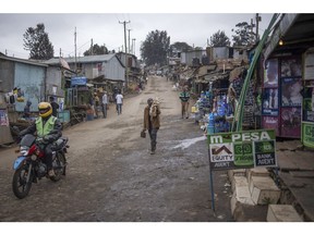 A mobile money kiosk, right, on a street in the Kibera district of Nairobi, Kenya, on Monday, Aug. 1, 2022. Kenyans will head to the polls on Aug. 9 to choose a new president in a contest pitting fifth-time contender Raila Odinga against William Ruto, a challenger who's anchored his campaign on a rags-to-riches story. Photographer: Michele Spatari/Bloomberg