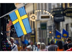 A Swedish national flag hanging from a shop in Gamla Stan in Stockholm, Sweden, on Thursday, Aug. 18, 2022. Sweden's government forecast the economic expansion to stall next year as high inflation and rising rates weigh on household consumption. Photographer: Mikael Sjoberg/Bloomberg