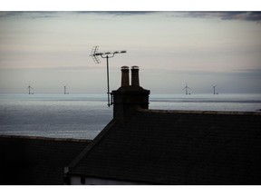 Offshore wind turbines beyond residential houses along the coast in Aberdeen, UK, on Wednesday, July 20, 2022. Aberdeen in northeast Scotland is trying to make the leap from an oil town to a renewables hub amid growing demand for cheap home-grown energy.