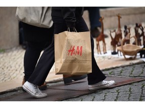 A shopper carries a Hennes and Mauritz AB (H&M) bag in Lisbon, Portugal, on Tuesday, Dec. 6, 2022. Inflation in the European Union is reaching its peak, according to Economy Commissioner Paolo Gentiloni. Photographer: Zed Jameson/Bloomberg