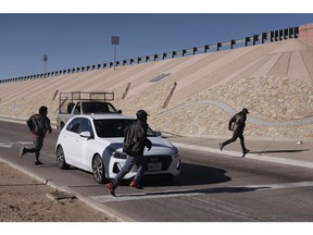 Migrants attempt to evade law enforcement after crossing the US and Mexico border in El Paso, Texas, US, on Tuesday, Dec. 22, 2022. Chief Justice John Roberts temporarily blocked the scheduled ending of pandemic-era border restrictions while the US Supreme Court considers a bid by Republican state officials to keep the rules in place during a legal fight.