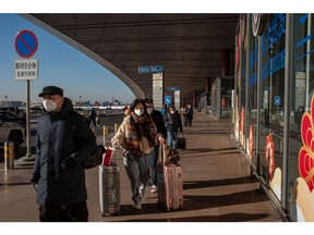 People push their luggage at Beijing Capital International Airport in Beijing, China, on Friday, Dec. 30, 2022. China could see as many as 25,000 deaths a day from Covid-19 later in January, casting a shadow over the start of the first Lunar New Year festivities without pandemic restrictions.