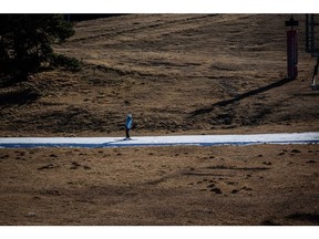 A skier heads down a thin run of snow, surrounded by dry ground, in Girona, Spain. Photographer: Angel Garcia/Bloomberg