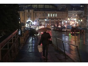 A shopper walks along a road at night in Kyiv, Ukraine, on Thursday, Jan. 5, 2023.