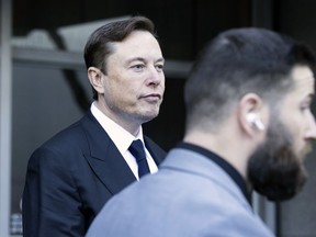 Elon Musk leaves the Phillip Burton Federal Building and United States Court House in San Francisco, Tuesday, Jan. 24, 2023. Musk returned to federal court to defend himself against a class-action lawsuit that alleges he misled Tesla shareholders with a tweet about an aborted buyout that the billionaire defiantly insisted Tuesday he could have pulled off, had he wanted.