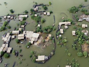 FILE - Homes are surrounded by floodwaters in Sohbat Pur city, a district of Pakistan's southwestern Baluchistan province, Aug. 30, 2022. This past year has seen a horrific flood that submerged one-third of Pakistan, one of the three costliest U.S. hurricanes on record, devastating droughts in Europe and China, a drought-triggered famine in Africa and deadly heat waves all over.