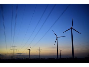 SEHNDE, GERMANY - MARCH 10: High-tension power lines and wind turbines are seen at dawn near a coal-fired Kraftwerk Mehrum power plant at Haemelerwald on March 10, 2015 near Sehnde, Germany. Energy production from conventional-based resources is becoming less profitable as renewable energy production has expanded and matured in Germany in the last decade. RWE, one of Germany's biggest utilities, today warned of pending job cuts due to financial losses derived from its conventional energy production. The Kraftwerk Mehrum plant is majority-owned by Stadtwerke Hannover AG.