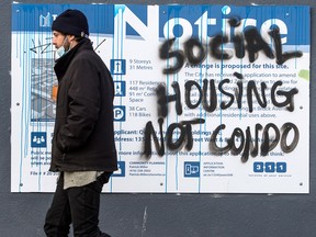 A pedestrian walks past graffiti stating “Social Housing Not Condo” in downtown Toronto. Housing demand in Canada is stronger than official estimates suggest, argues a economist.