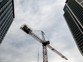 A crane standing between two condo buildings.