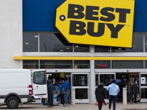 Shoppers visit a Best Buy to find deals during Black Friday, in Toronto on November 26, 2021. Best Buy, the country's biggest consumer electronics chain, is laying off close to one per cent of its workforce, estimated to be about 700 employees. Anna LeGresley, a spokeswoman for Best Buy Canada, says the company made the difficult decision to say goodbye to some team members. She says the job losses come as the retailer works to "support our stores and serve our customers."